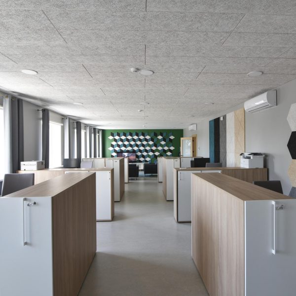 sivé akustické panely na strope a hexagorálne a kosoštvorcové akustické panely na stene v kancelárií